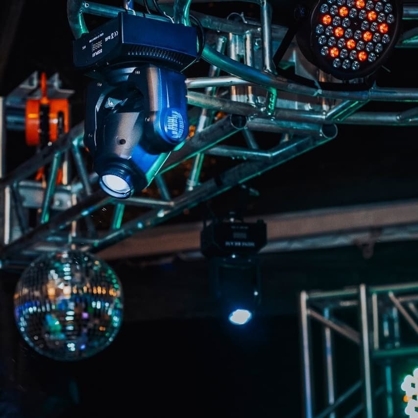 Moving heads, refletores e globo espelhado presos na estrutura de treliça