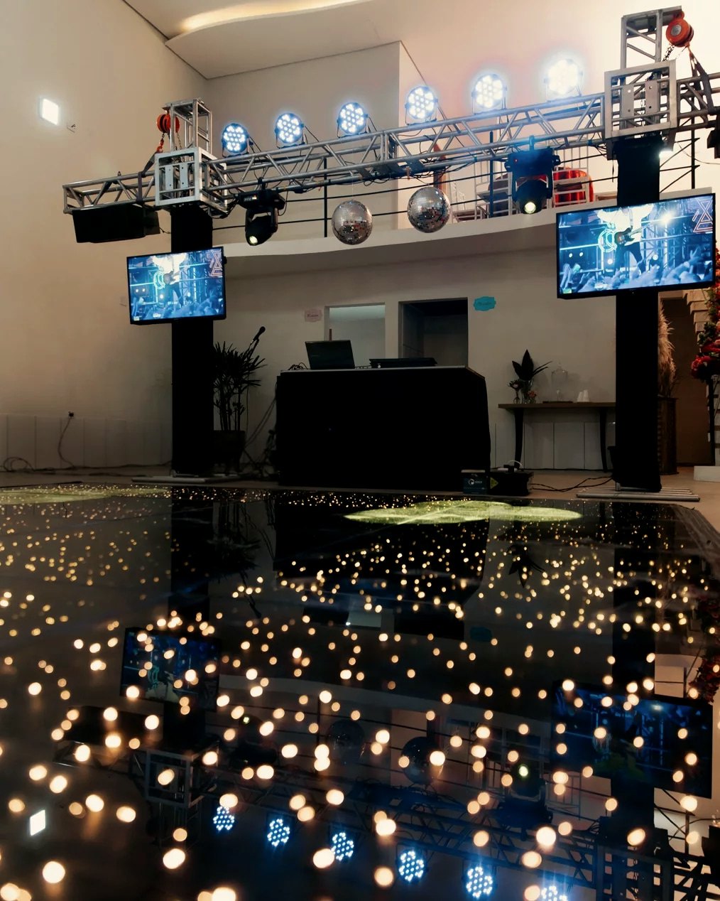 Treliça com refletores, moving heads e globos espelhados, TVs nas colunas e a Pista Paris montada à frente